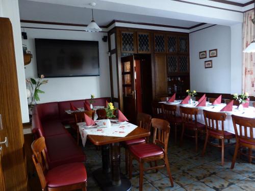 a dining room with tables and chairs and a flat screen tv at Zwehrener Hof in Kassel