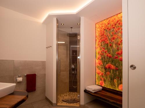 een badkamer met een schilderij van bloemen op de muur bij Ferienwohnung Papst in Bad Lippspringe