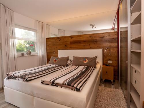 Schlafzimmer mit einem großen Bett mit einem Kopfteil aus Holz in der Unterkunft Ferienwohnung Papst in Bad Lippspringe