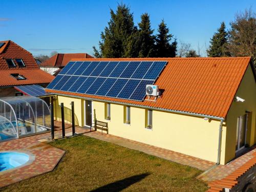 an image of a house with solar panels on the roof at Csónak Vendégház in Dávod