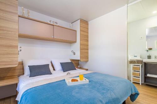 a bedroom with a bed with a tray of food on it at Perla - Lux Mobile Homes in Rovinj