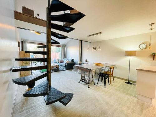 une salle à manger et un salon avec un escalier en colimaçon dans une maison dans l'établissement ⧗ Lisle au Trésor ⧗ Loft d'architecte avec jardin, à Lisle-sur-Tarn