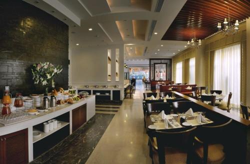 a dining room with tables and chairs in a restaurant at Park Inn Gurgaon in Gurgaon