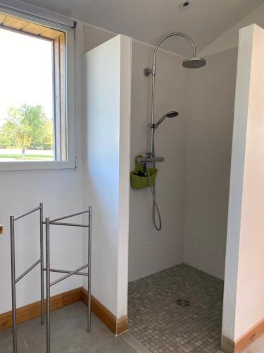 La salle de bains est pourvue d'une douche et d'une fenêtre. dans l'établissement La Chambre de Claire, à Les Iffs