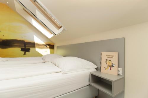 a bedroom with a bed and a book on a shelf at Ponty-Papa Rendezvényház in Dávod