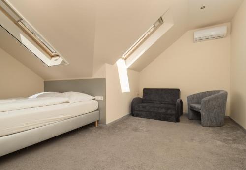 a bedroom with a bed and a chair at Ponty-Papa Rendezvényház in Dávod