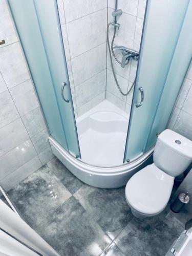 a bathroom with a shower and a white toilet at 2Lustra in Białystok