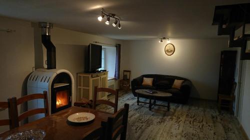 un salon avec une table et une cheminée dans l'établissement viaux-fontaine, à Saulxures-sur-Moselotte