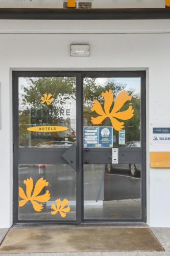 a store door with yellow flowers on it at Premiere Classe Thionville - Yutz in Basse-Yutz