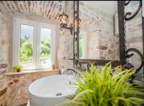uma casa de banho com um lavatório e um espelho em Holiday Home Bogumila em Risan