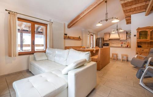 a living room with a white couch and a kitchen at Chalet Paradisi in Castello Tesino
