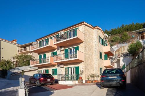 twee auto's geparkeerd voor een gebouw bij Villa Borzic in Omiš