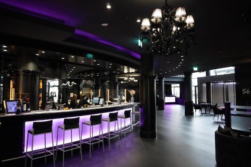 un bar en un restaurante con iluminación púrpura en stays by friends Gelsenkirchen, en Gelsenkirchen