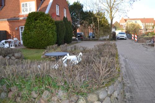 a garden with a bench and a table on a street at Nordlicht in Wyk auf Föhr