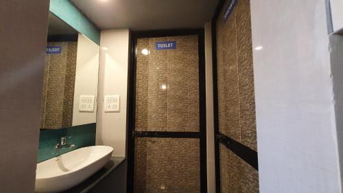 a bathroom with a sink and a toilet and a shower at Pappi Chulo Vagator in Vagator