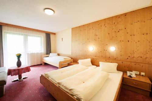 duża sypialnia z 2 łóżkami i oknem w obiekcie Hotel Steuxner w Neustift im Stubaital