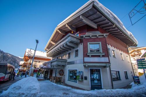 a building in the snow next to a bus at Kramerhaus Viehhofen in Viehhofen