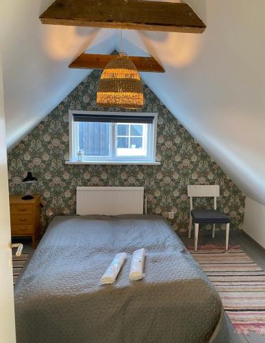 a bedroom with a bed with two towels on it at Villa Havsro,charmig skånelänga med 200 m till havet in Farhult