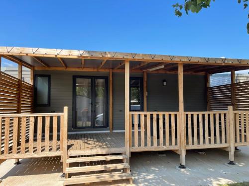 a screened in porch of a house with a wooden deck at Camping LES PEUPLIERS in Hyères
