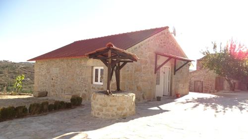 a stone house with a statue in front of it at Quinta do Cruzeiro in Mata