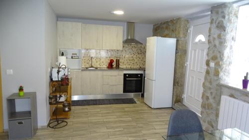 a kitchen with a white refrigerator and a table at Quinta do Cruzeiro in Mata