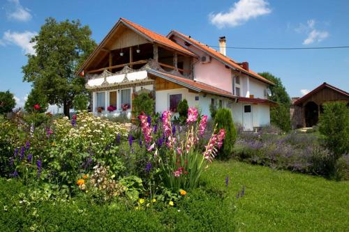a house with a field of flowers in front of it at Apartment in Rakovica with Wi-Fi (601-3) in Rakovica