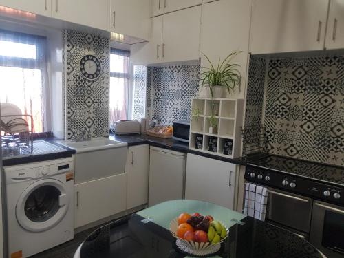 a kitchen with a bowl of fruit on a table at Saphire Glasgow Apartments in Giffnock