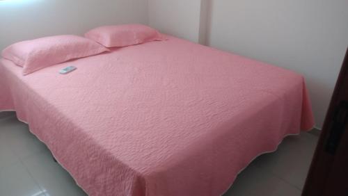 a pink bed with a pink blanket on it at Lindo apartamento frente ao mar. in São José da Coroa Grande