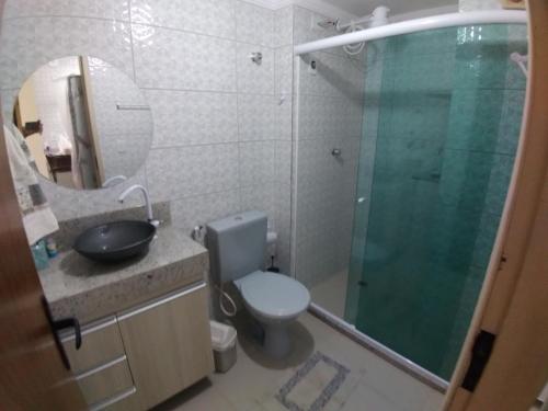 La salle de bains est pourvue de toilettes et d'une douche en verre. dans l'établissement Lindo apartamento frente ao mar., à São José da Coroa Grande