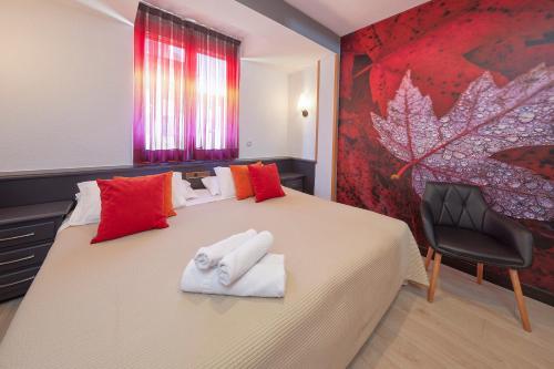 a bedroom with a bed with two towels on it at Hotel Sanchez in Aínsa