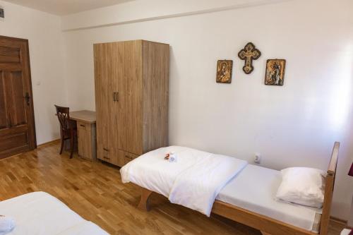 a room with two beds and a cross on the wall at Guest Mansion, Гостински Палат in Rostuša
