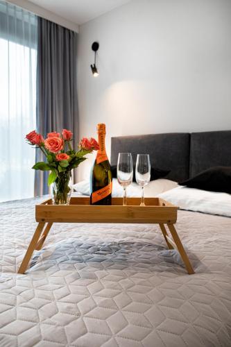 a table with two wine glasses and a bottle of champagne at EASY RENT APARTAMENTS - Silver 9, Basen & SPA, Centrum Free Parking 24h Check-in in Lublin
