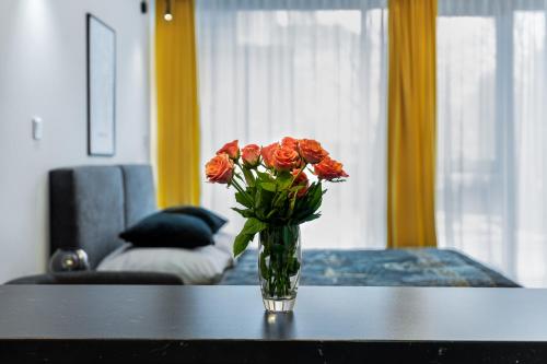 a vase of red flowers sitting on a table at EASY RENT Apartments - Silver 8, Basen & SPA, Centrum Free Parking 24h Check-in in Lublin