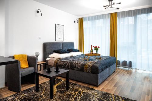 een slaapkamer met een bed, een bank en een stoel bij EASY RENT Apartments - SILVER 8 in Lublin