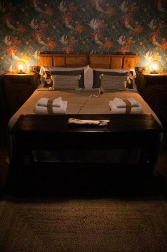 a bedroom with a large bed with two lights on it at RAICES Casa Rural in Torre de Don Miguel