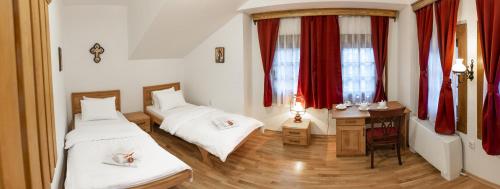 a room with two beds and a desk and a table with a desk at Guest Mansion, Гостински Палат in Rostuša