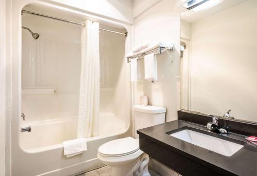 a bathroom with a sink and a toilet and a tub at Econo Lodge Glade Springs I-81 in Glade Spring