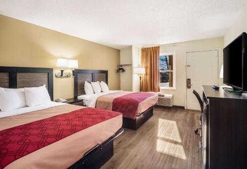 a hotel room with two beds and a flat screen tv at Econo Lodge Glade Springs I-81 in Glade Spring