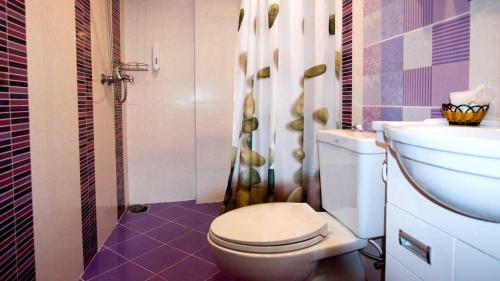 a bathroom with a toilet and a sink at Bluebird Inn Pattaya in Pattaya Central