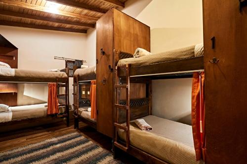 a room with four bunk beds and a rug at The Secret Garden in Quito