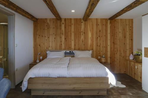 um quarto com uma cama e uma parede de madeira em Studio 1111 with Sauna & Hot Tub em Dravograd
