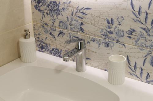 a bathroom sink with a blue and white wallpaper at Studio 1111 with Sauna & Hot Tub in Dravograd