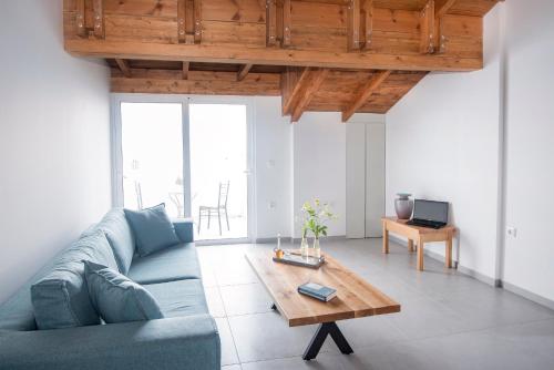 a living room with a blue couch and a coffee table at PanoramiKos in Asfendioú