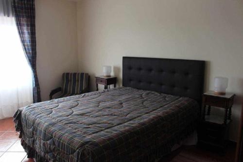 a bedroom with a large bed and a chair at River House, T2 Tavira – Santa Luzia in Tavira