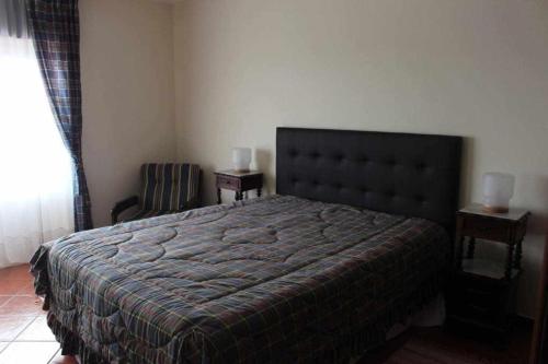 um quarto com uma cama grande e uma cadeira em River House T2 Tavira Santa Luzia em Tavira