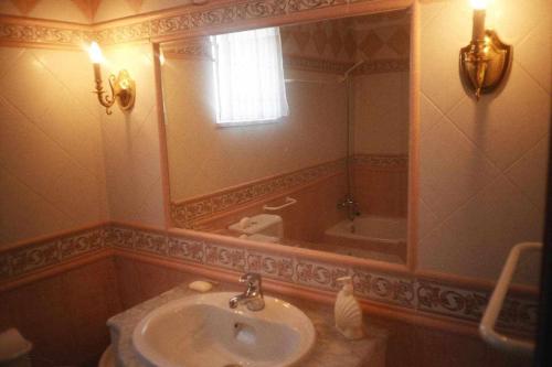 uma casa de banho com um lavatório, um espelho e uma banheira em River House T2 Tavira Santa Luzia em Tavira