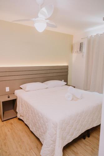 a white bed in a bedroom with a ceiling at Pousada Velas do Forte in Cabo Frio