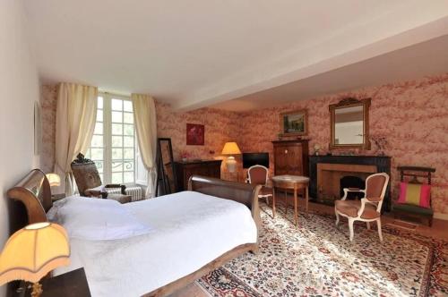 - une chambre avec un grand lit et une cheminée dans l'établissement Du Vignoble à l'Atlantique - Château Cassemichère gîte, à La Chapelle-Heulin