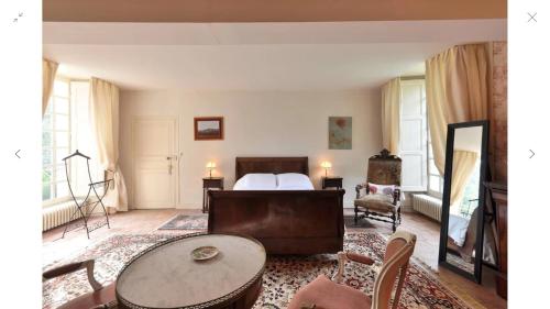 Un dormitorio con una cama y una mesa y sillas. en Du Vignoble à l'Atlantique - Château Cassemichère gîte, en La Chapelle-Heulin
