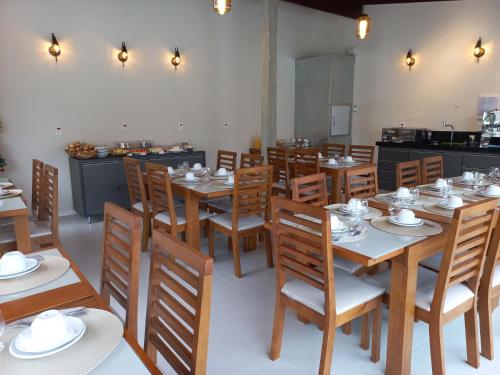 a dining room with wooden tables and wooden chairs at Pousada Velas do Forte in Cabo Frio